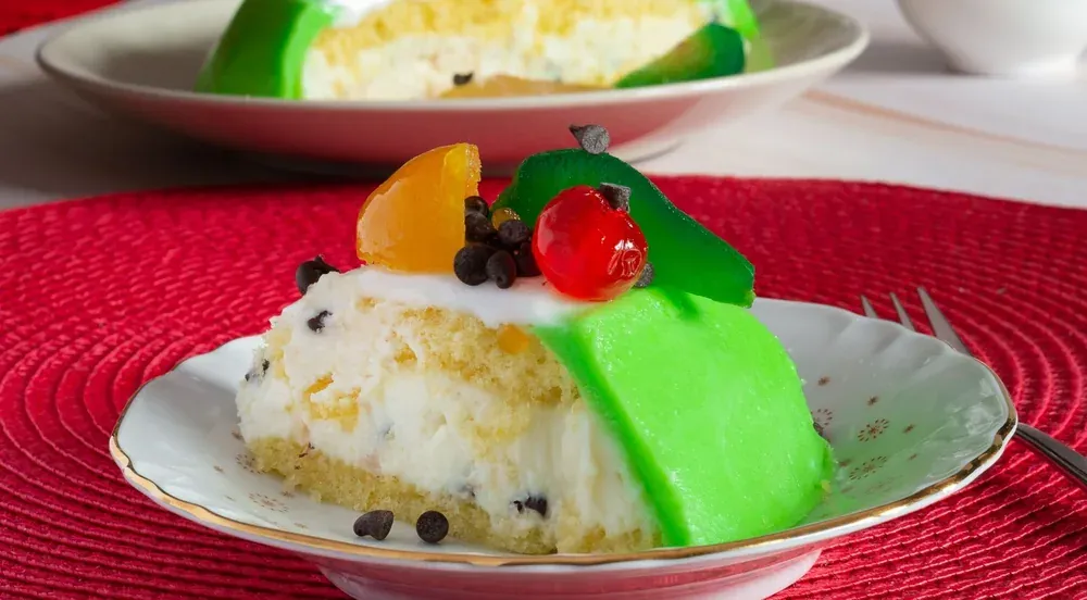 A slice of cassata siciliana with green marzipan and candied fruit