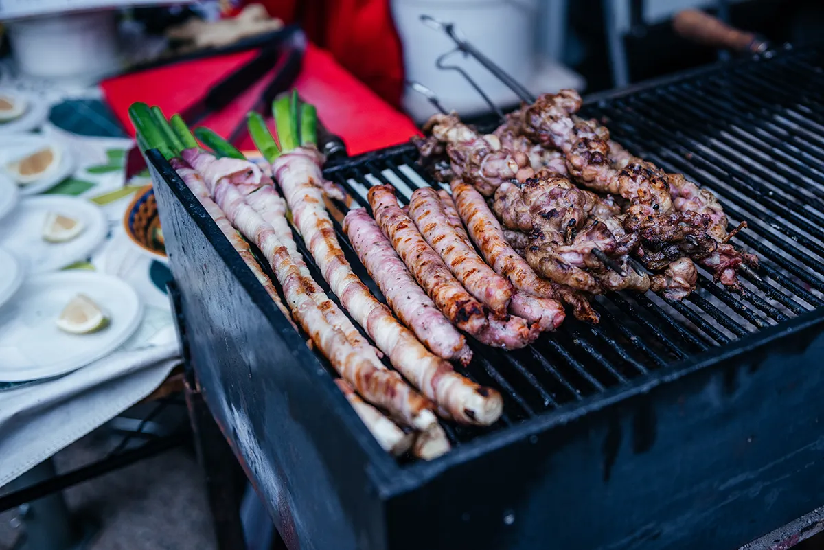 Cipollate and sausages on a charcoal grill in a Palermo market