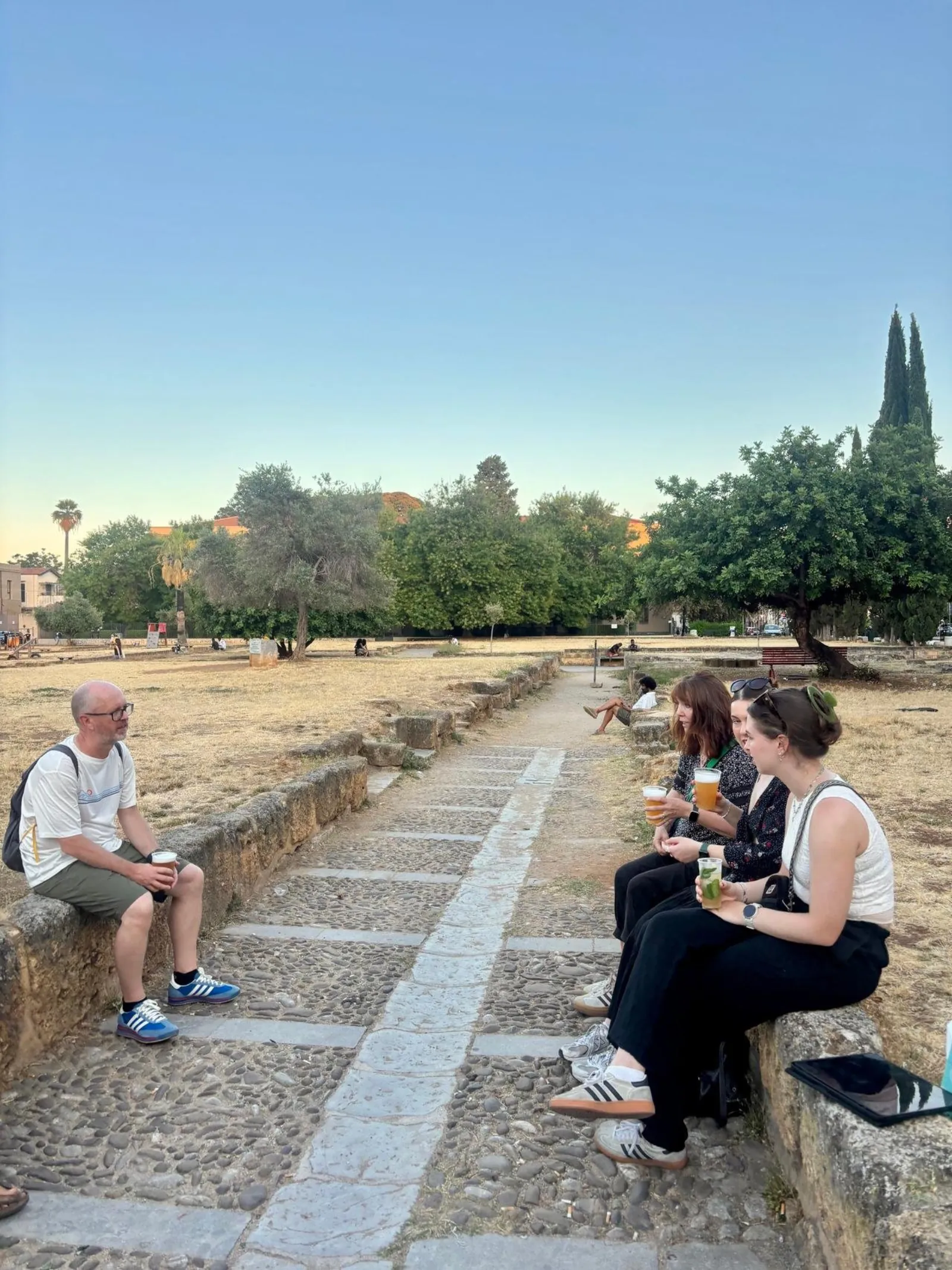 Guests resting on a stone wall in a Palermo garden