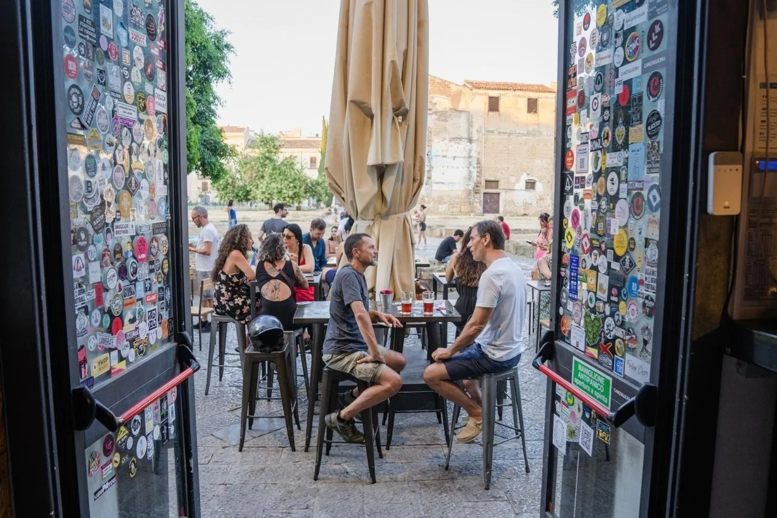 An outdoor bar seen through a sticker-covered doorway
