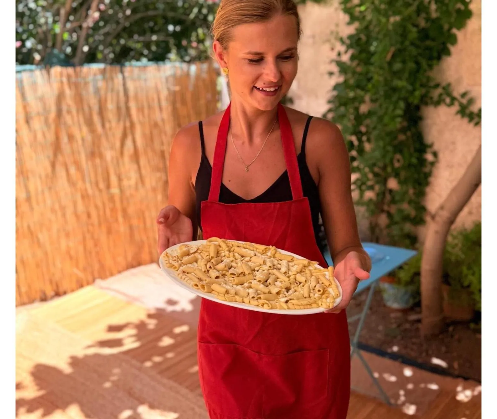 A guest holding a plate of the pasta she made