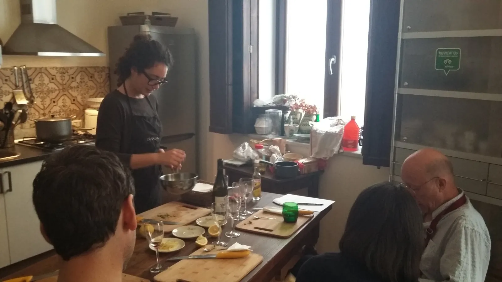 The chef cooking while guests watch at the kitchen table