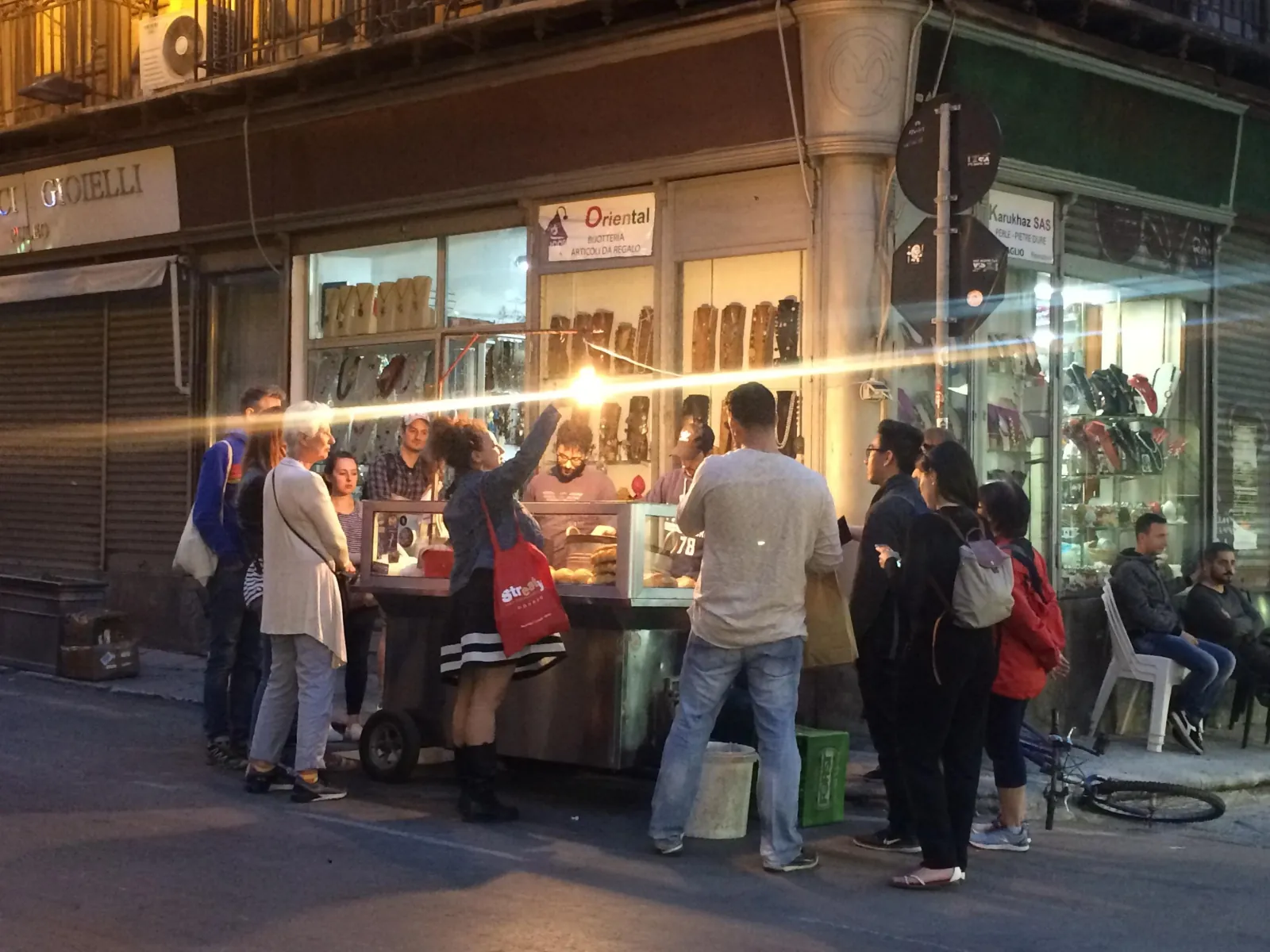 Guests at an evening street food counter on a Palermo street