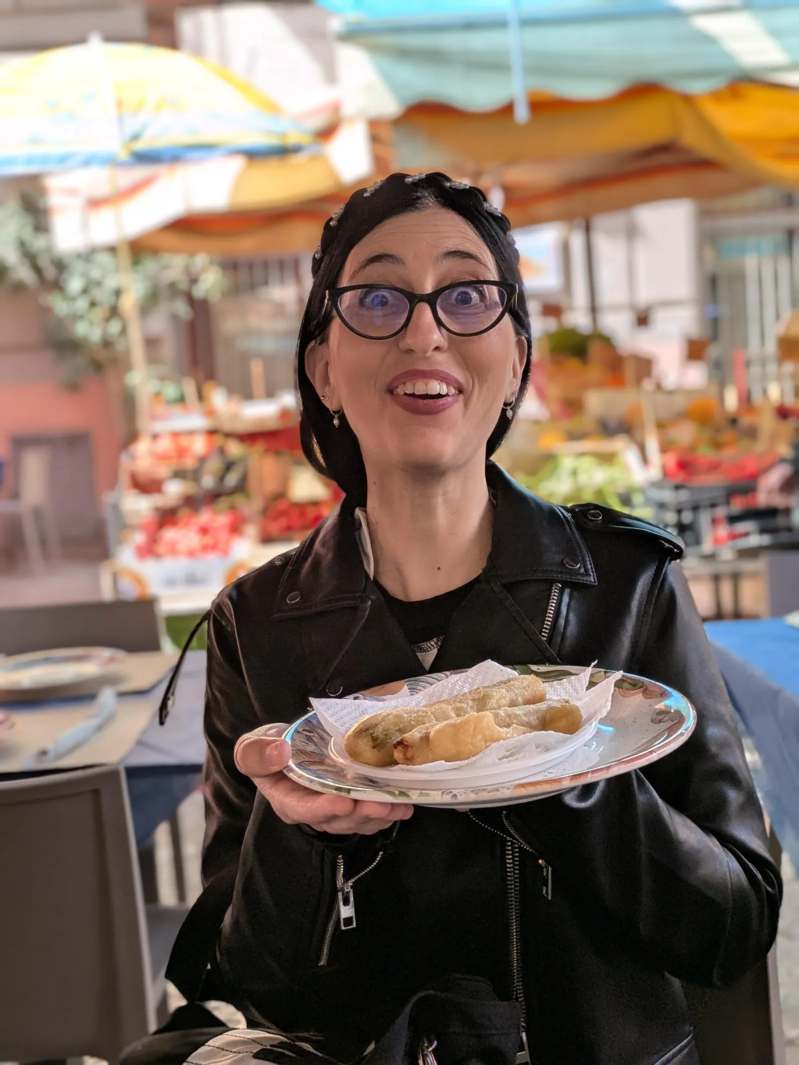 A guest holds a plate of panelle in a Palermo market
