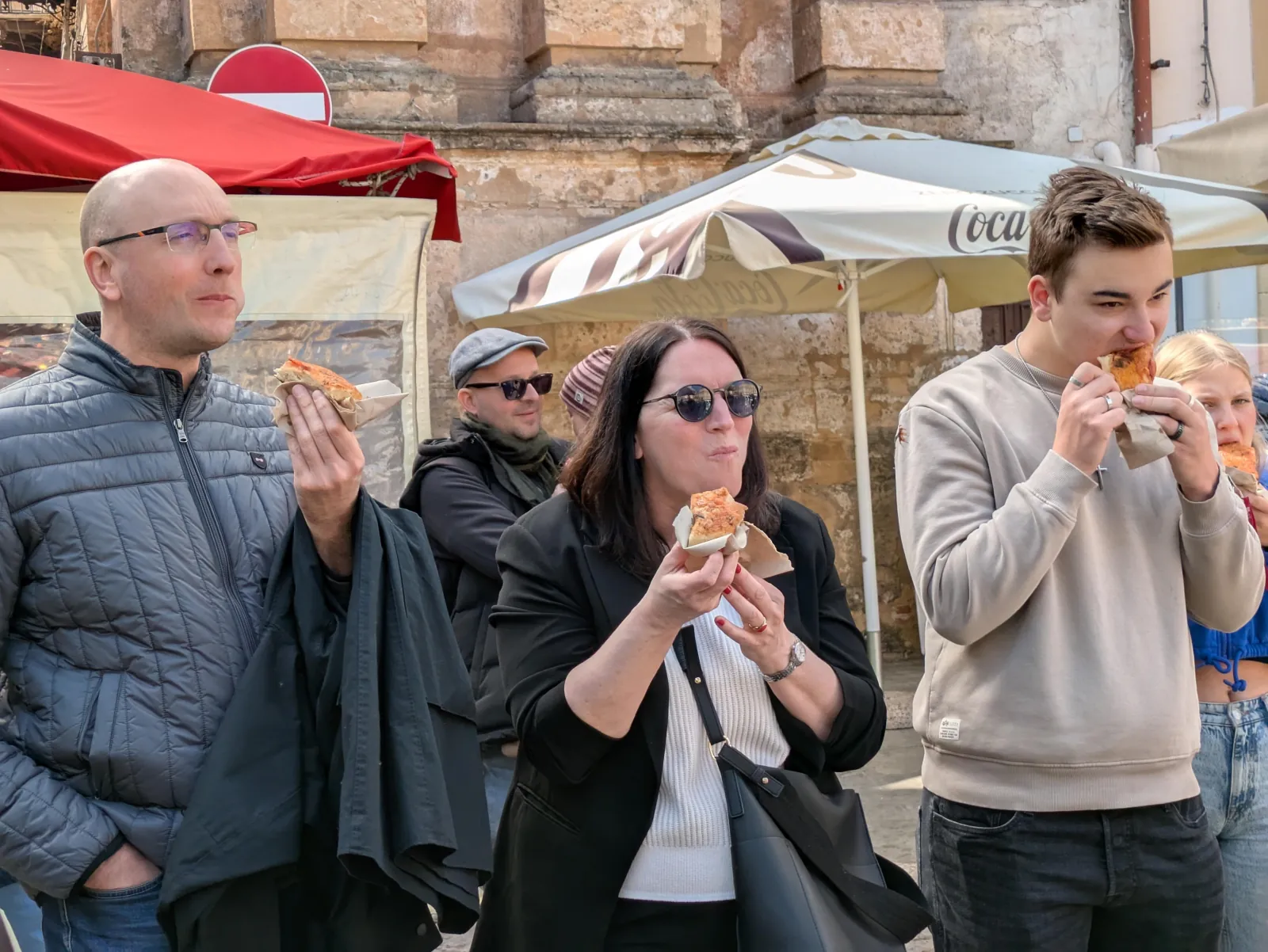 Guests eating sfincione in a Palermo square