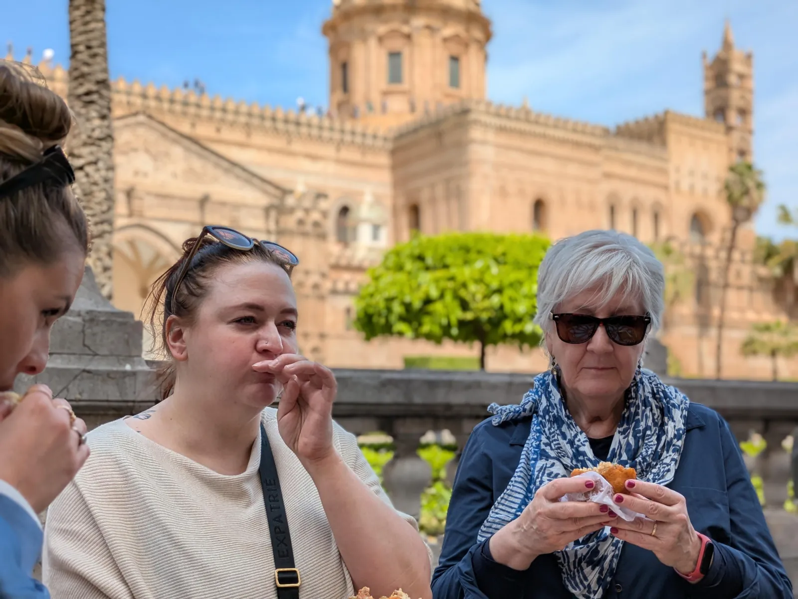 Guests eating street food in front of Palermo Cathedral