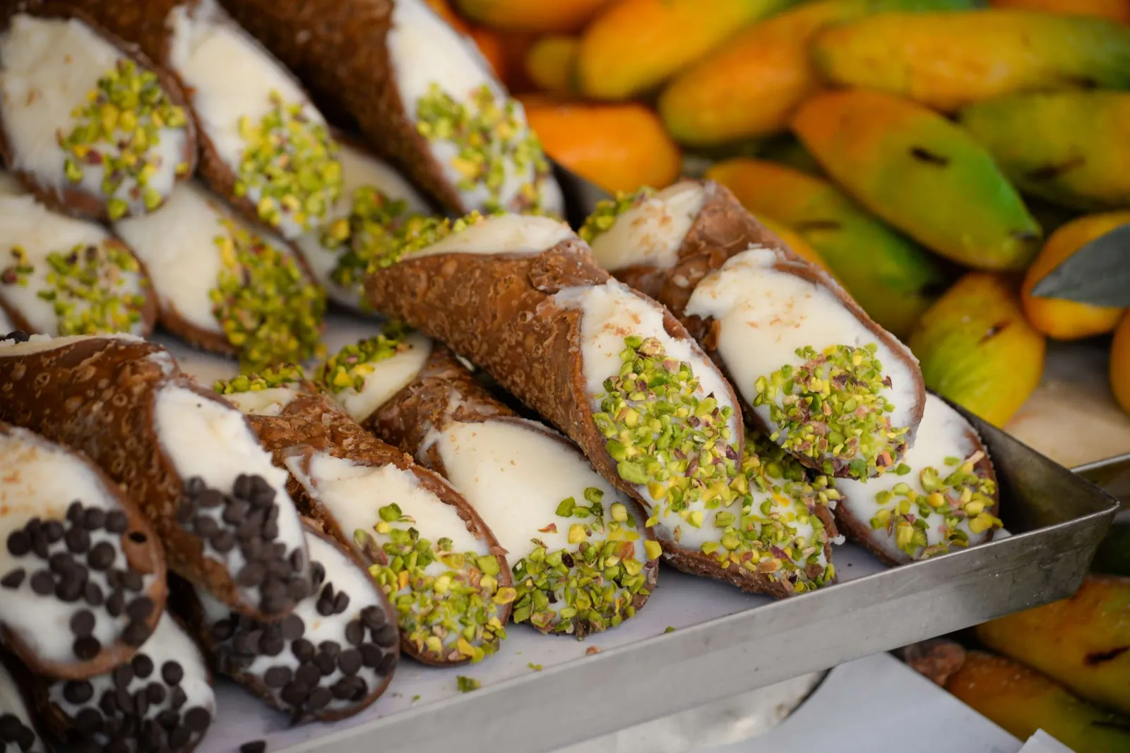 Rows of cannoli with pistachio and chocolate ends