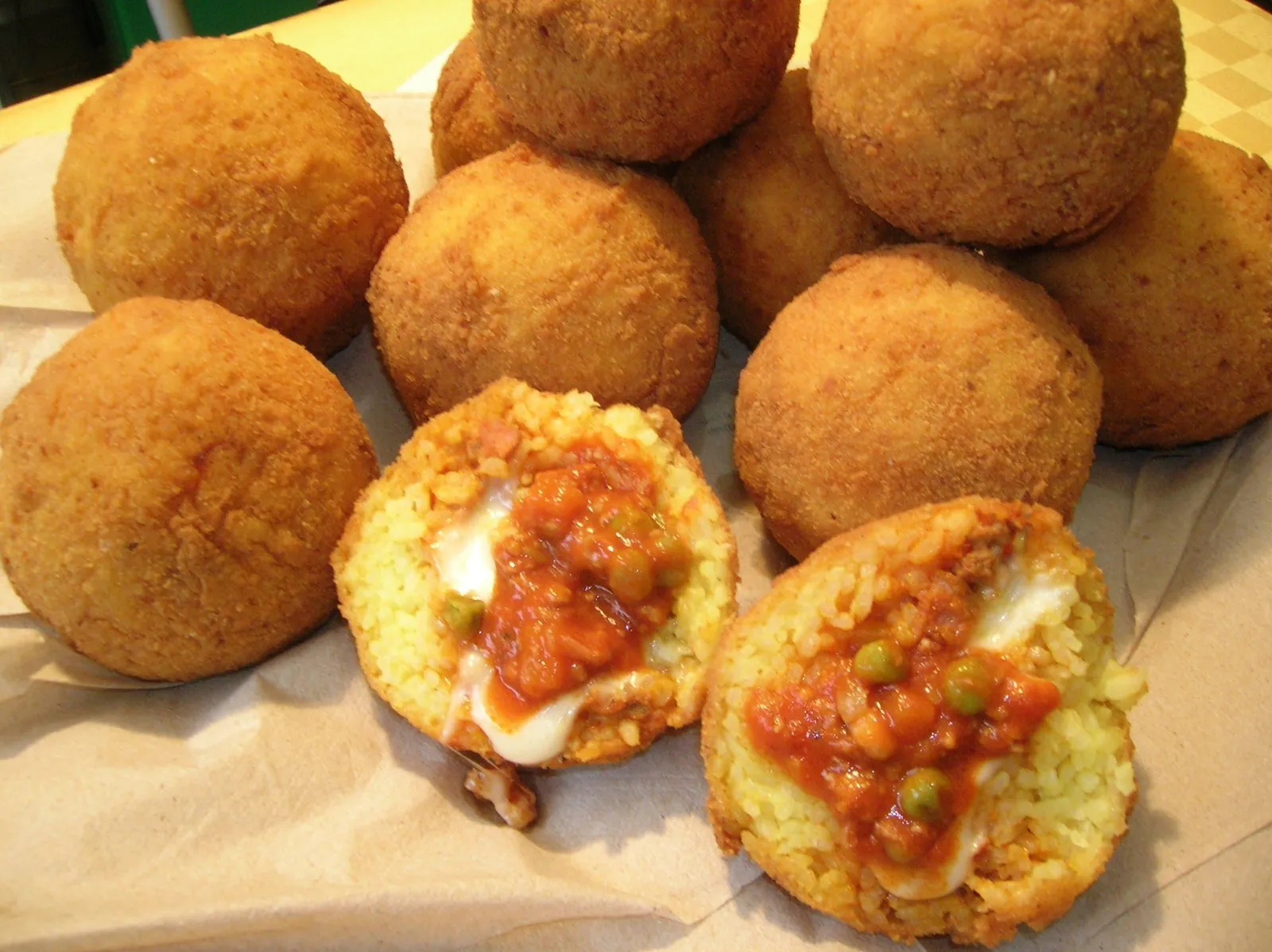 Arancine broken open to show the ragù and cheese filling