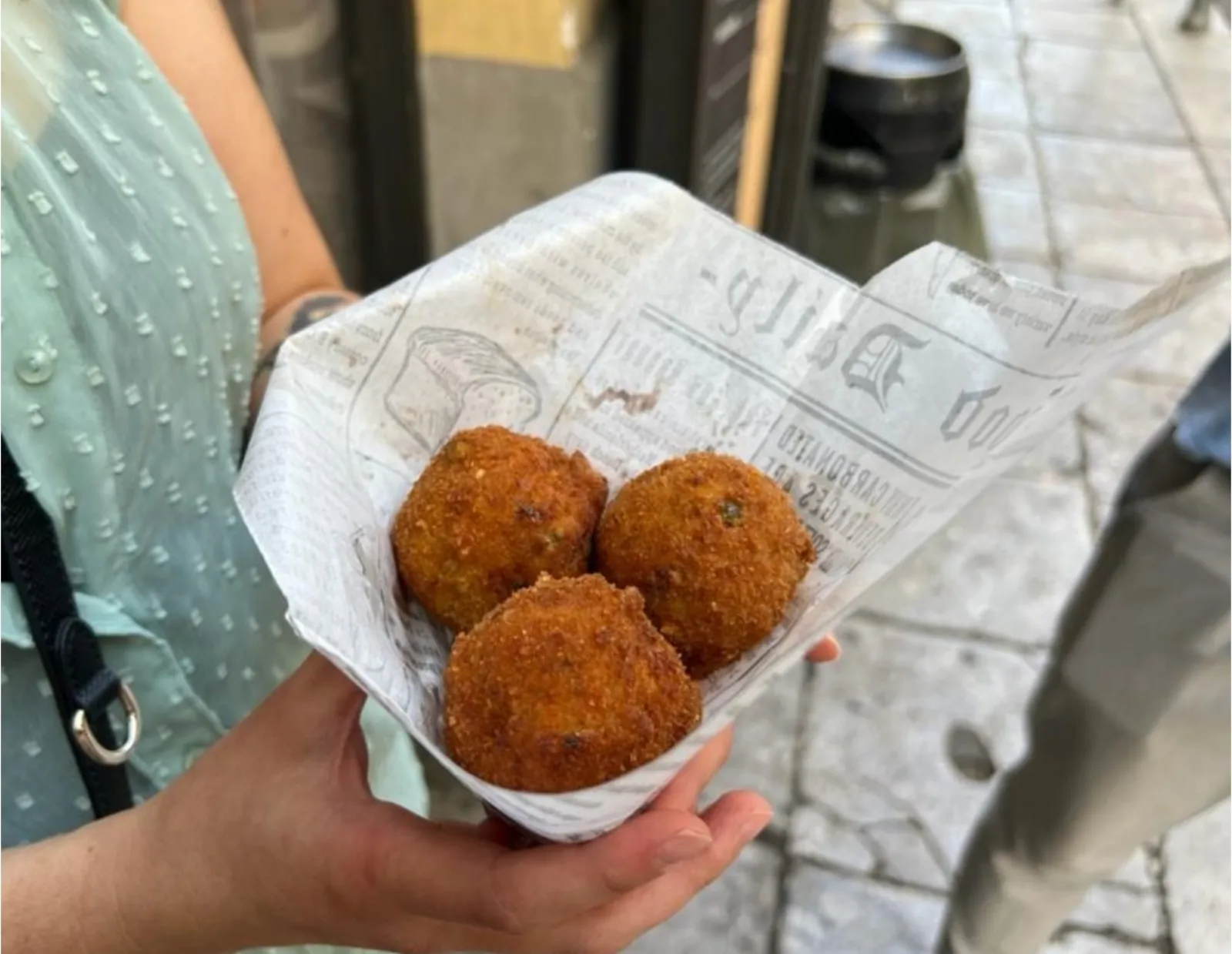 Three arancine in a paper cone