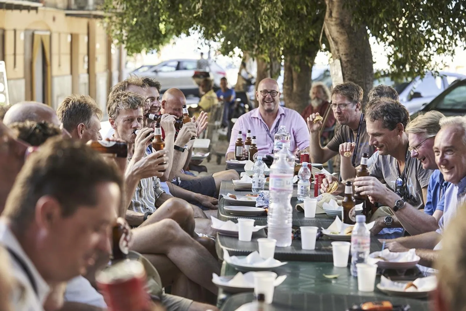 Cyclists sharing food and drinks at an outdoor table