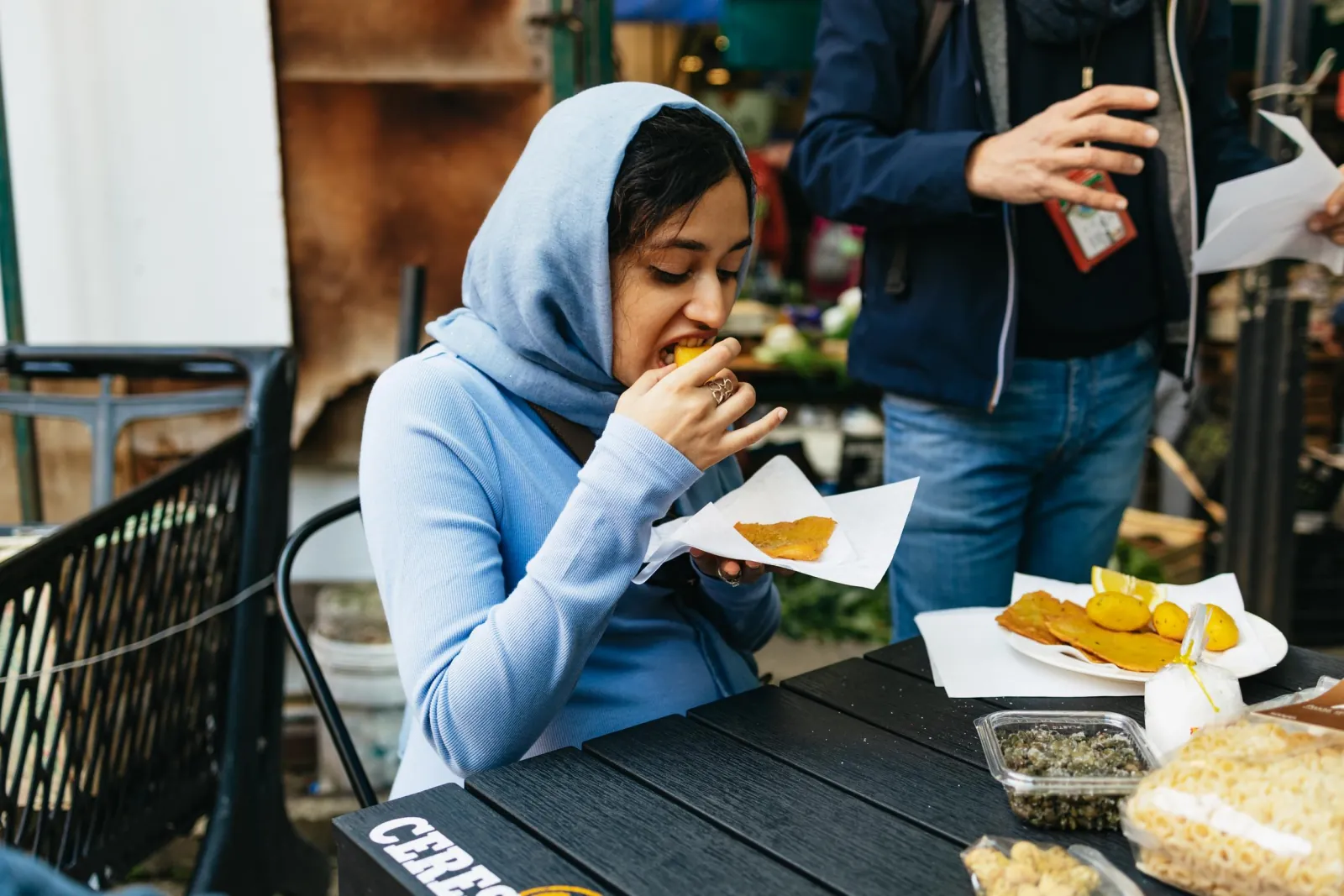 A guest eats panelle at an outdoor table on the street food tour
