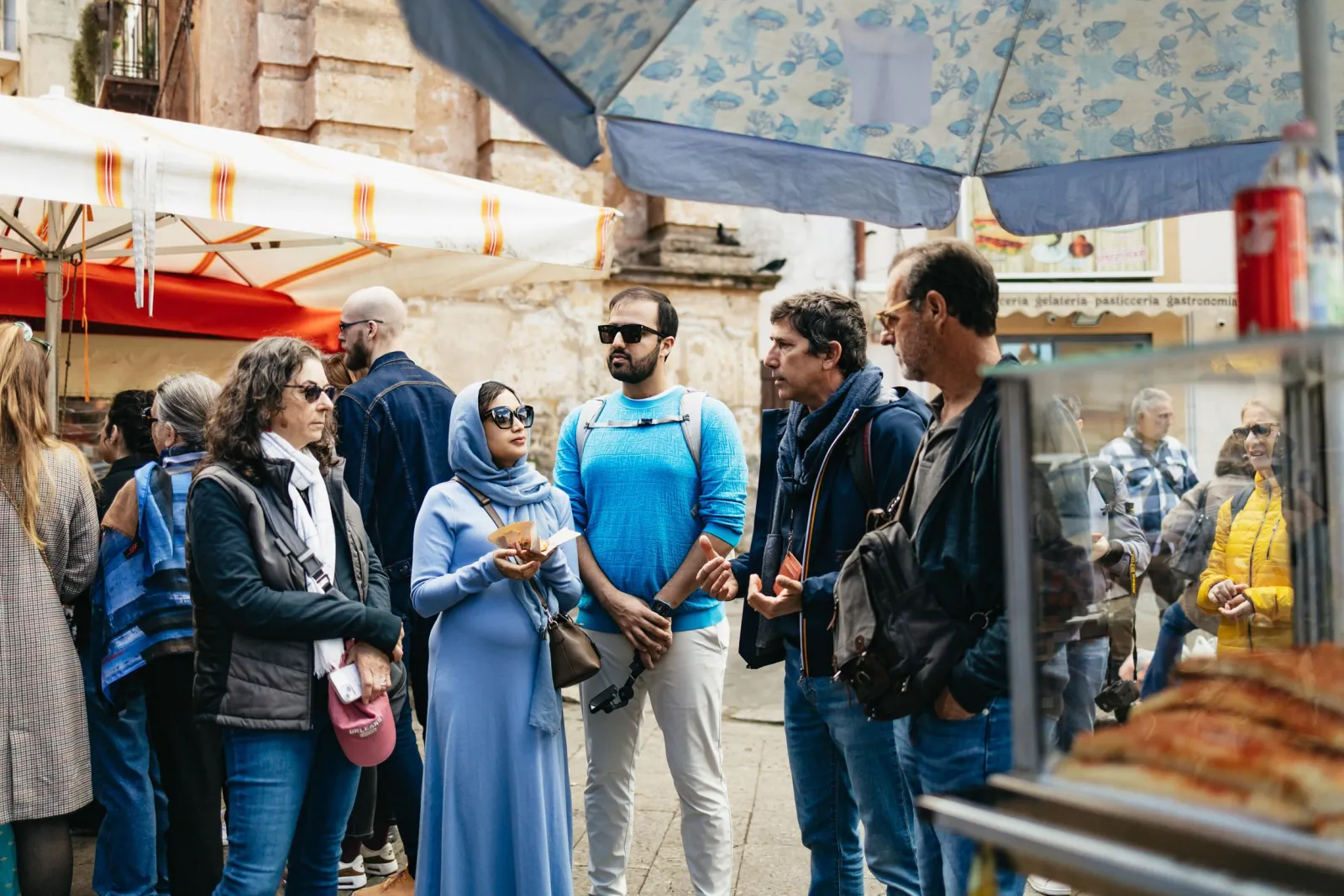 The group gathers around the guide at a market stall