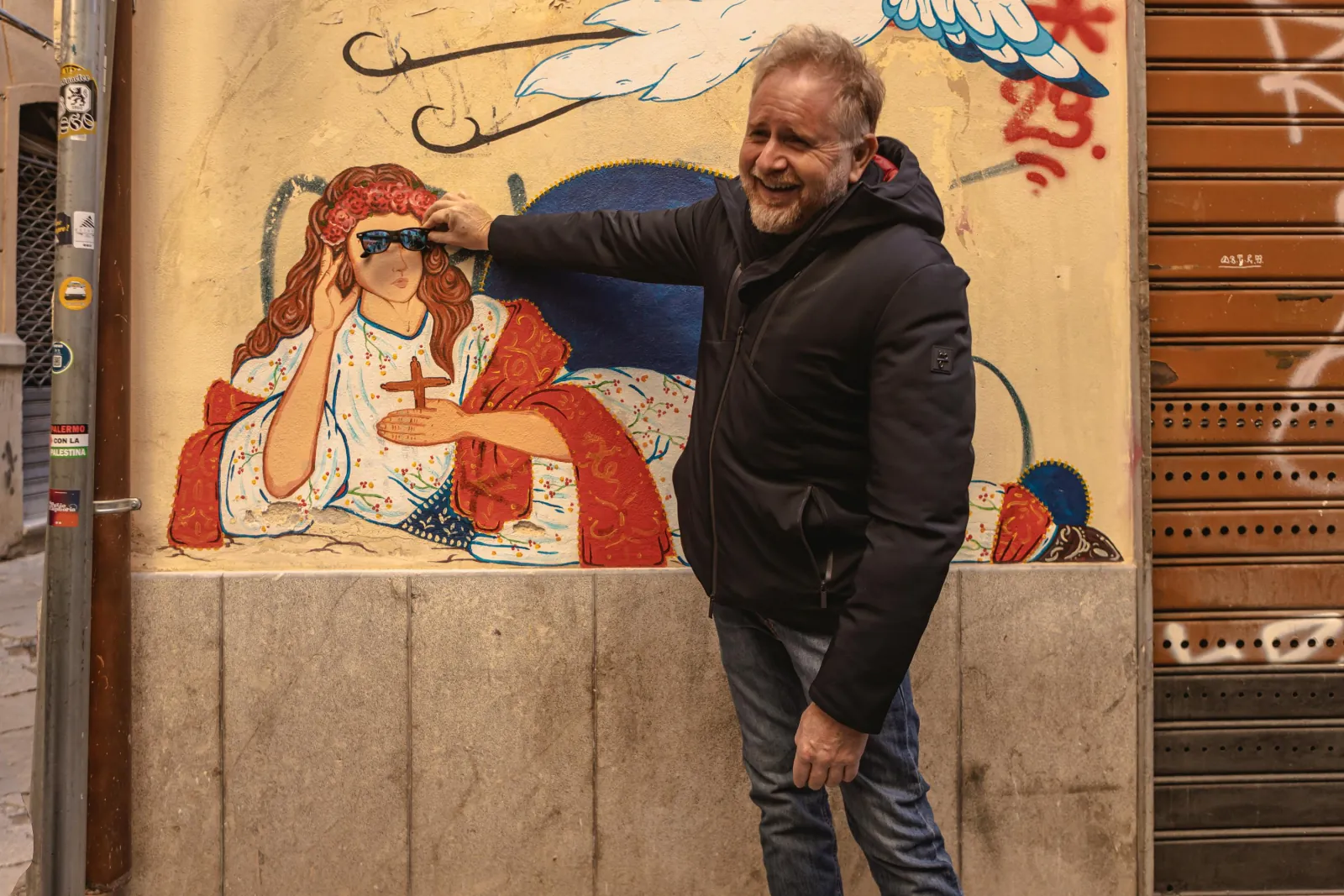 A guest beside a street mural in the old town