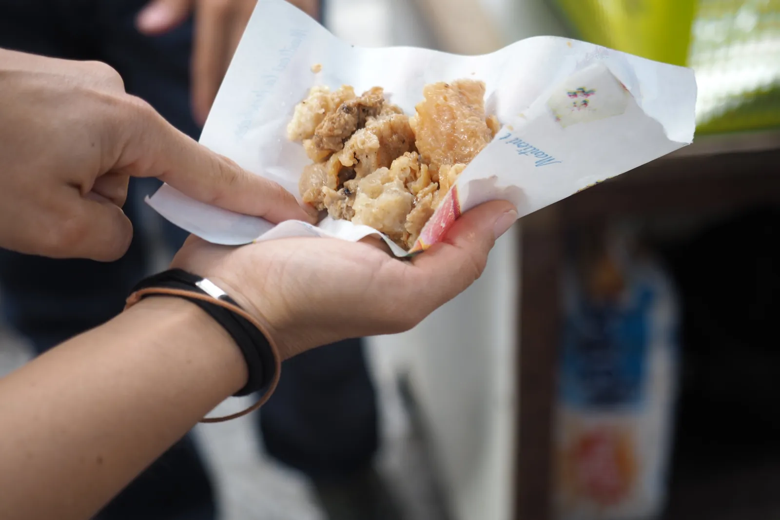 A paper cone of fried street food held up in a Palermo market